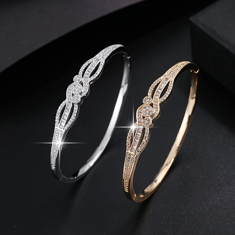 سوار نسائي أنيق باللون الذهبي - تصميم حلقة متشابكة مع أحجار مميزة براقة، مجوهرات يومية وحفلات للملابس الرسمية غير الرسمية - إكسسوار فاخر على مدار العام، مزين بأحجار الزركونيا الصناعية، راقي