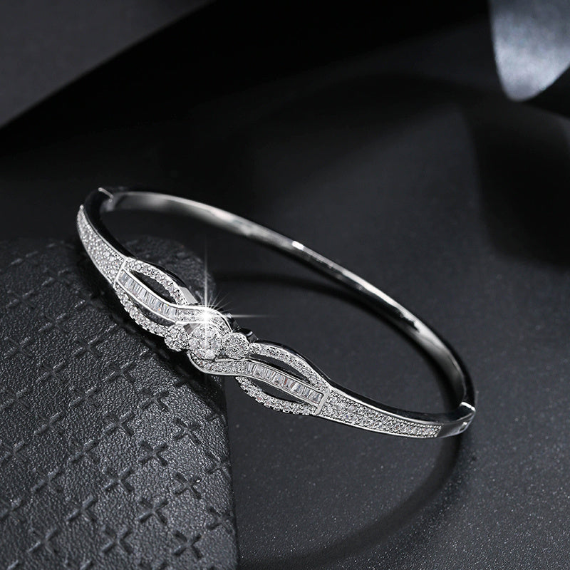 سوار نسائي أنيق باللون الذهبي - تصميم حلقة متشابكة مع أحجار مميزة براقة، مجوهرات يومية وحفلات للملابس الرسمية غير الرسمية - إكسسوار فاخر على مدار العام، مزين بأحجار الزركونيا الصناعية، راقي