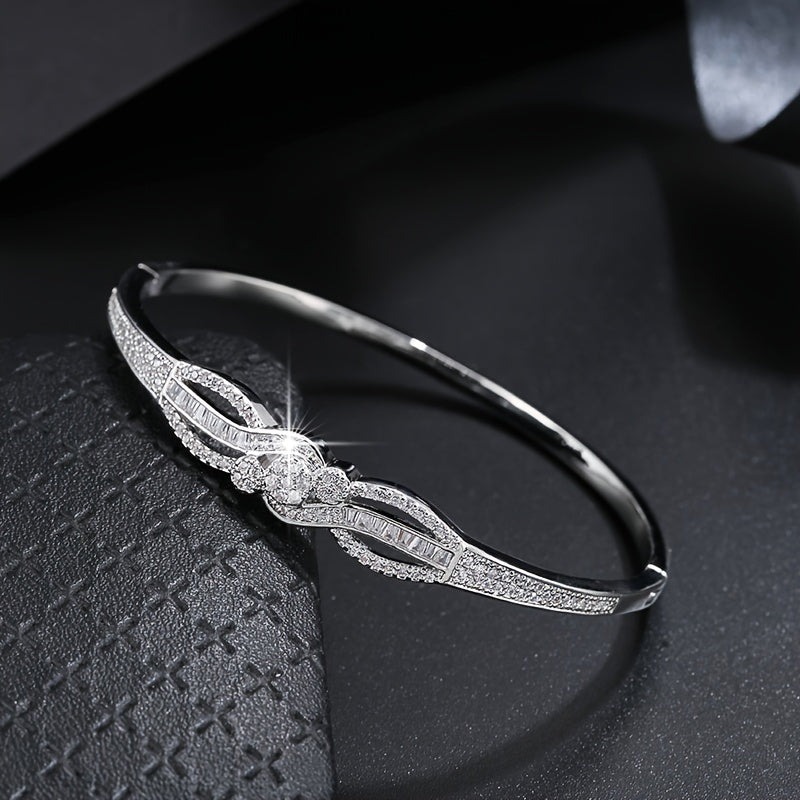 سوار نسائي أنيق باللون الذهبي - تصميم حلقة متشابكة مع أحجار مميزة براقة، مجوهرات يومية وحفلات للملابس الرسمية غير الرسمية - إكسسوار فاخر على مدار العام، مزين بأحجار الزركونيا الصناعية، راقي